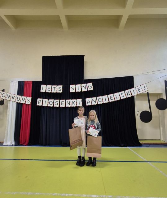 W minionym tygodniu dziewczynki z klasy 1a wzięły udział w międzyszkolnym konkursie piosenki anglojęzycznej pt.„Let’s Sing”. Zaprezentowały utwory „APT” oraz „Colors of Your Life”, w których pokazały nie tylko swoje umiejętności wokalne, ale także ogromną odwagę i sceniczny wdzięk. Ich występy wysoko podniosły poprzeczkę kolejnym uczestnikom.  Choć tym razem nie udało się stanąć na podium, dziewczynki otrzymały wyróżnienie z czego jesteśmy bardzo dumni. 