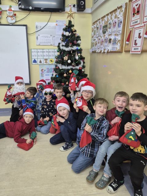 W piątek klasa 1a  świętowała Mikołajki, które od samego rana wprowadziły dzieci w świąteczny nastrój. Gdy uczniowie weszli do sali, czekała na nich niezwykła niespodzianka — pod choinką pojawiły się prezenty! Obok nich leżał również list od Świętego Mikołaja, w którym zostawił pierwszakom specjalne zadania do wykonania.
